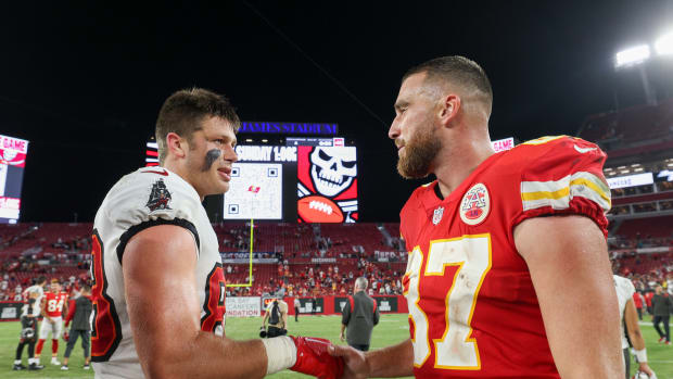 Kansas City Chiefs tight end Travis Kelce (87) greets Tampa Bay Buccaneers tight end Cade Otton (88) after a game at Raymond James Stadium.